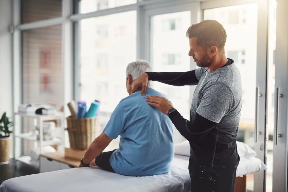 Chiropractor, healthcare and physical therapist and client for rehabilitation, massage or assessment